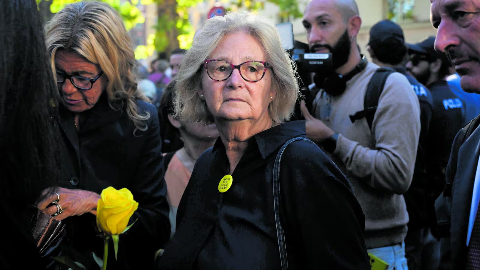Una donna con la spilla gialla «Verità per Giulio Regeni» in mezzo alla folla; accanto, una rosa gialla